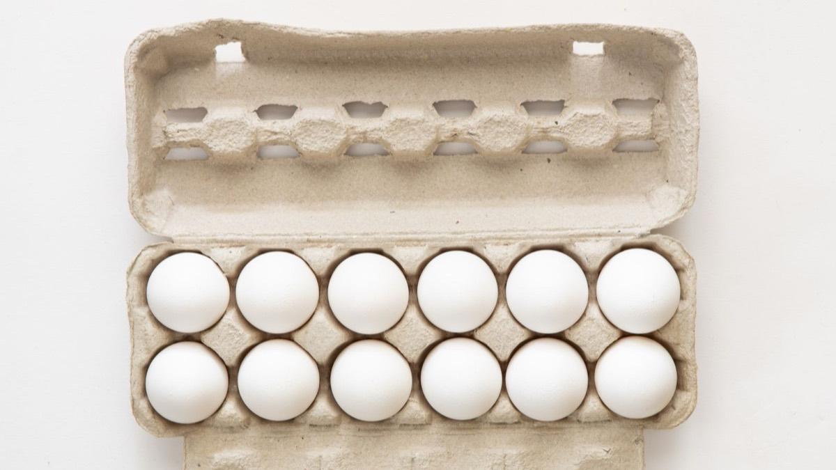 A carton of twelve white eggs in two rows of six