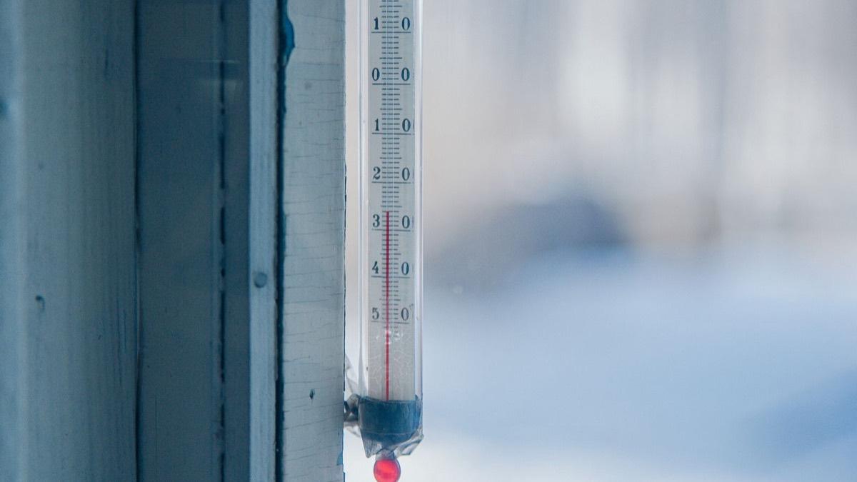 An outdoor thermometer on a window frame in frosty winter weather